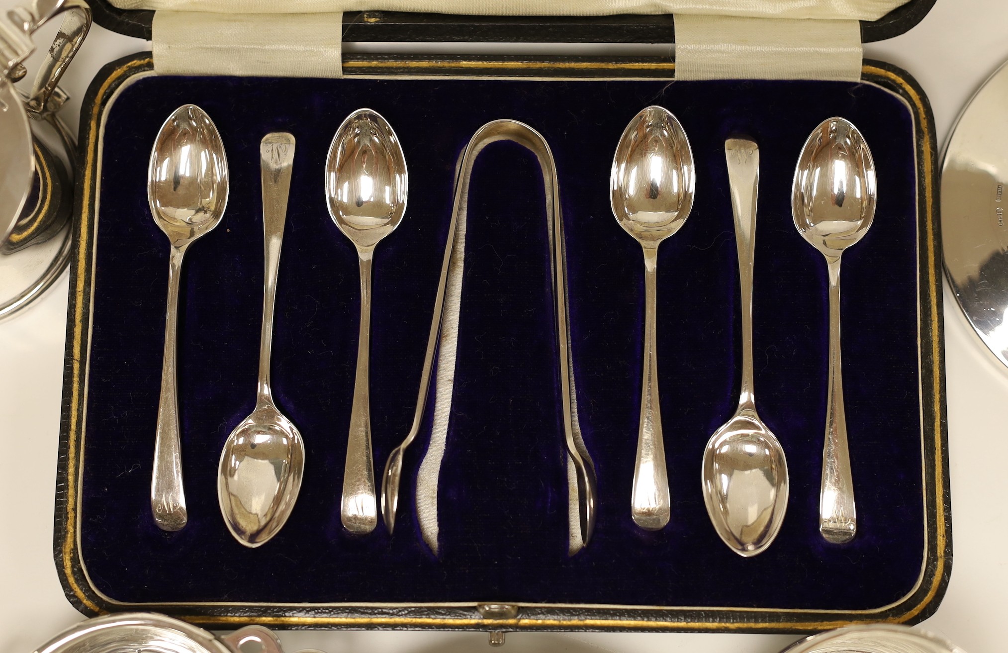 Small silver including a mounted inkwell, tea strainer on stand, mustard pot, small dish and cased set of six coffee spoons with sugar tongs.